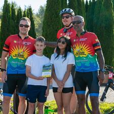 Two students accepting a plaque for their participation in raising funds for the Cops for Cancer/Tour de Valley.