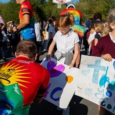 Tour de Valley rider signing student made sign.
