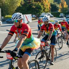 Tour de Valley riders on bikes, riding to be greeted by students.